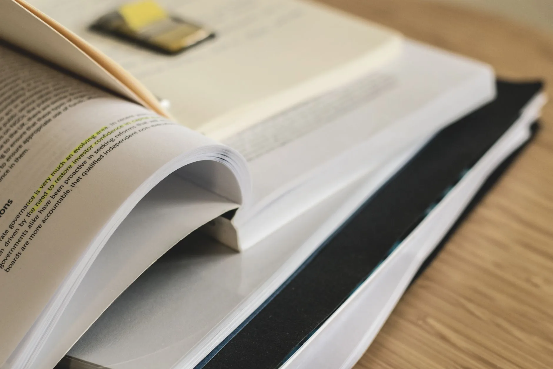 Stack of open books on a table representing academic study, citation styles, and research reference guides.