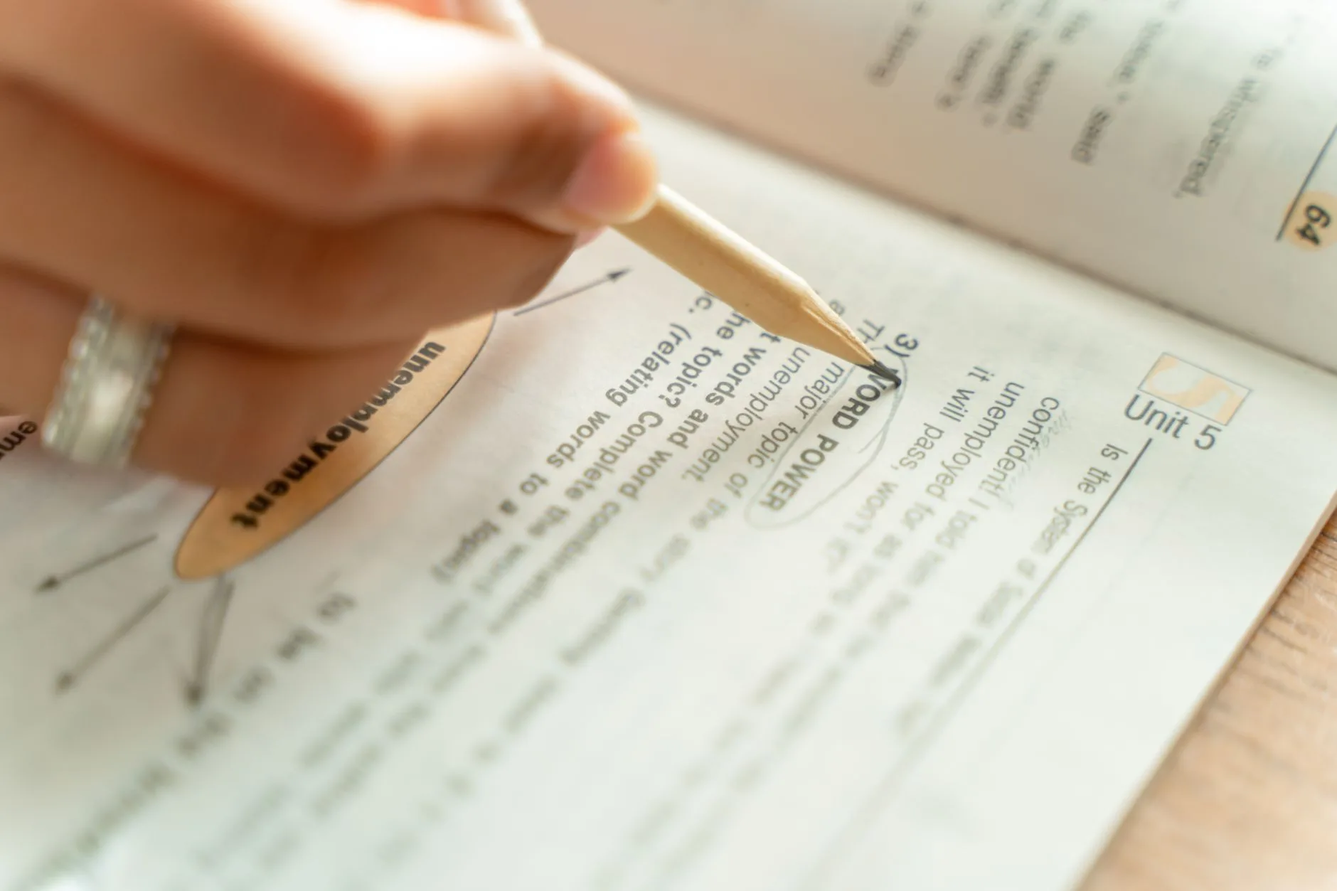 Woman writing notes in a textbook, representing the process of crafting an academic abstract step by step.