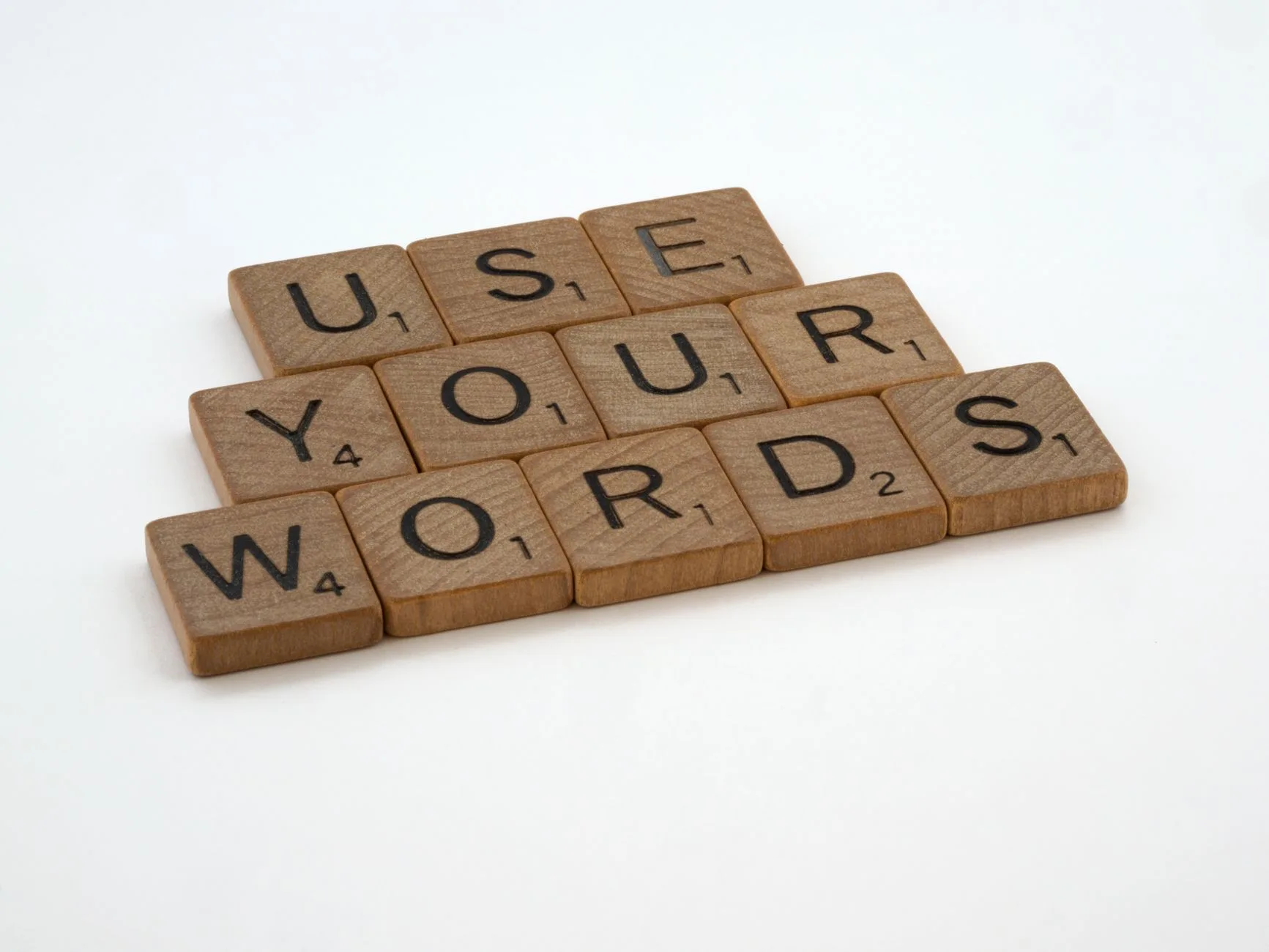 Scrabble tiles spelling out Improve Your Argument on a pink background